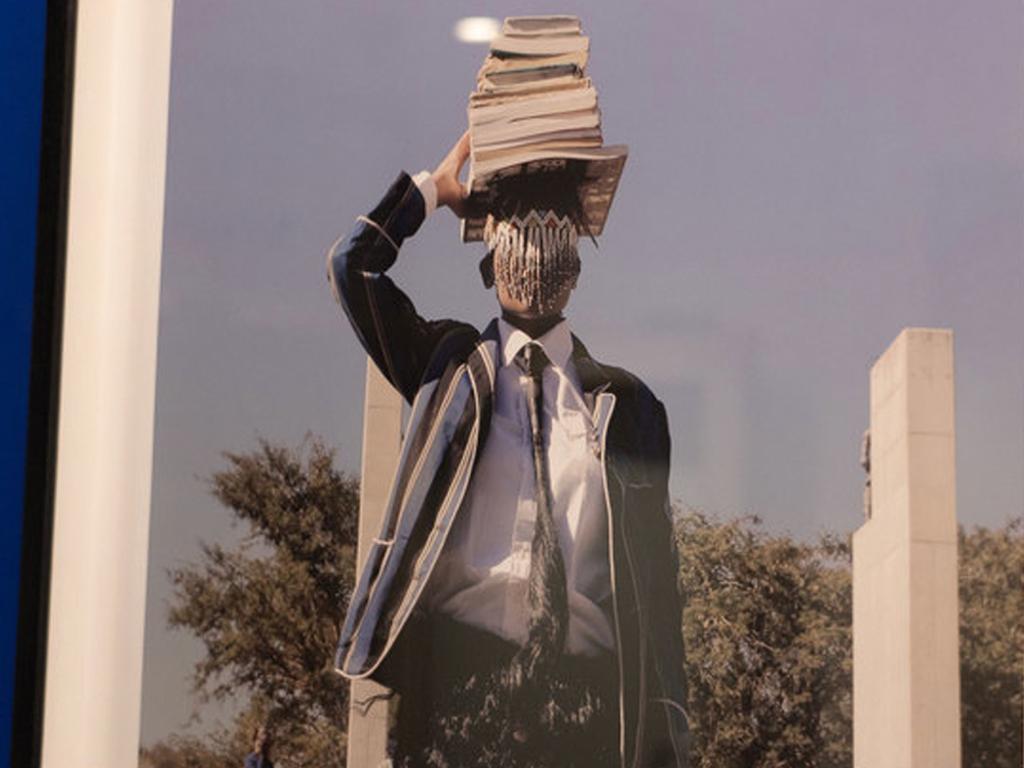 artwork depicting person in student uniform balancing books on head